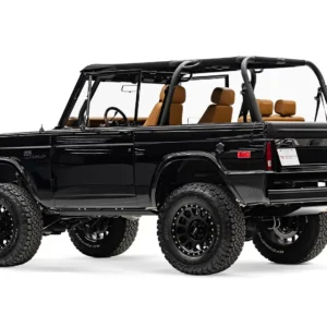 Black off-road SUV with rugged tires and tan interior seats.