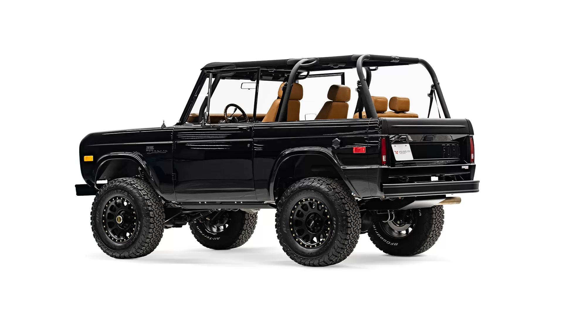 Black off-road SUV with rugged tires and tan interior seats.